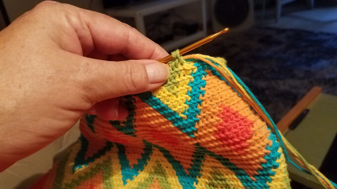 carrying the strands of yarn to make a tapestry crochet bag