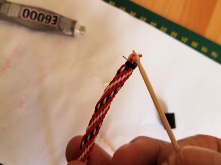 photo demonstrating how to apply glue to hold the end of a kumihimo braid