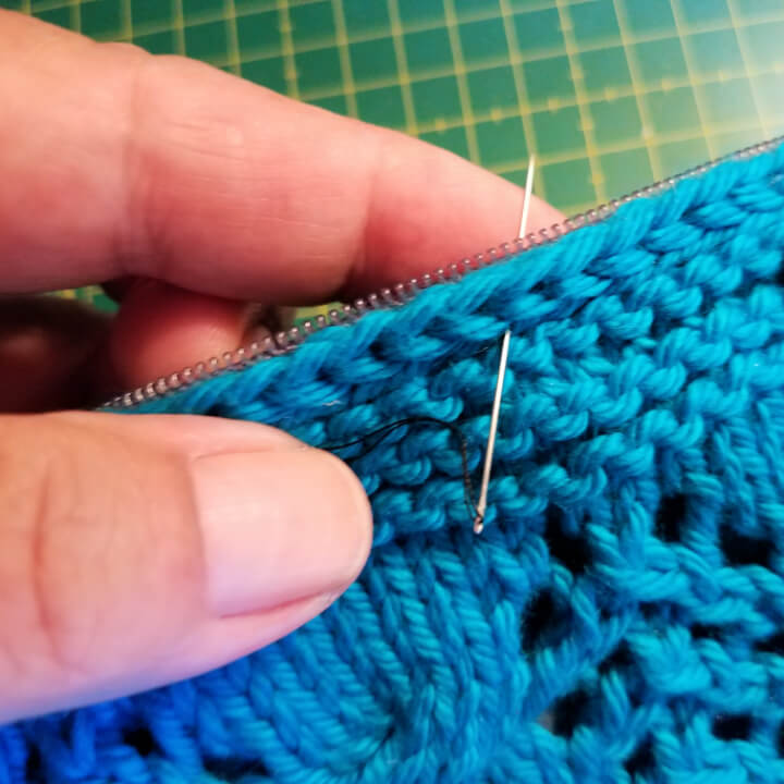 progress photo demonstrating hand sewing the zipper into a knit clutch