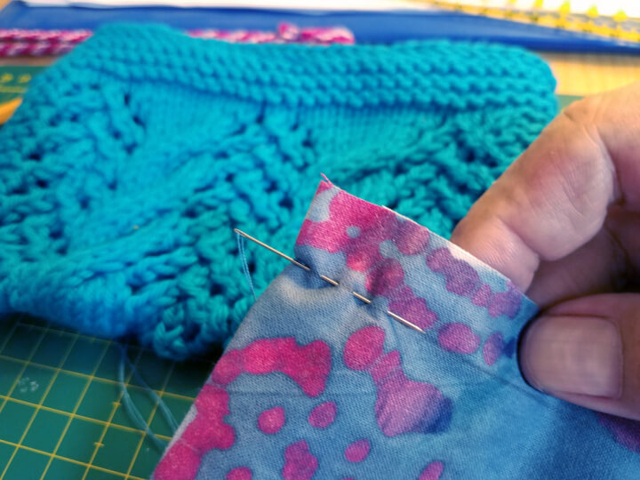 progress photo demonstrating hand sewing the lining for a knit clutch
