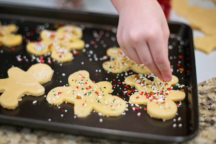 child's hand decorating cookies