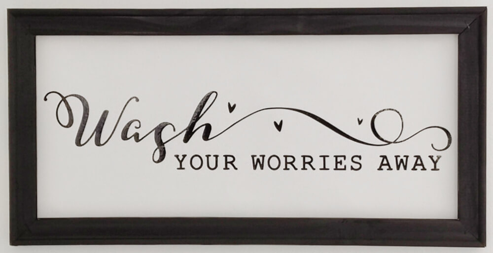 Easy bathroom update - a reverse canvas frame with the sentiment "Wash Your Worries Away"